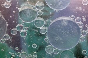 Close-up image of bubbles in liquid creating an abstract pattern.