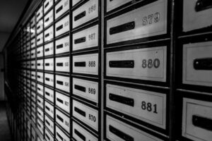 A striking black and white image featuring rows of organized mailboxes in a building interior.